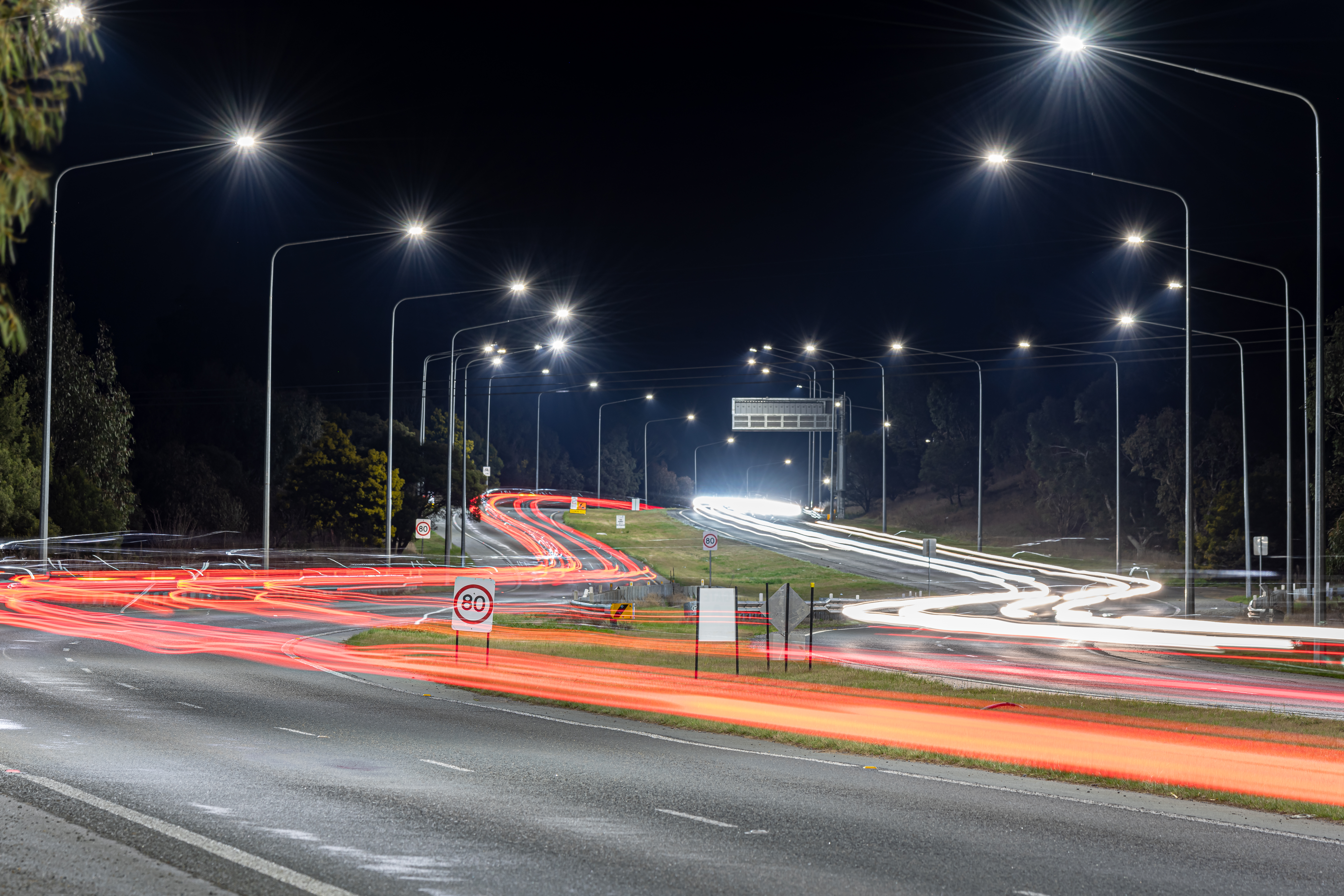 A curvy section of road with street lights on either side.